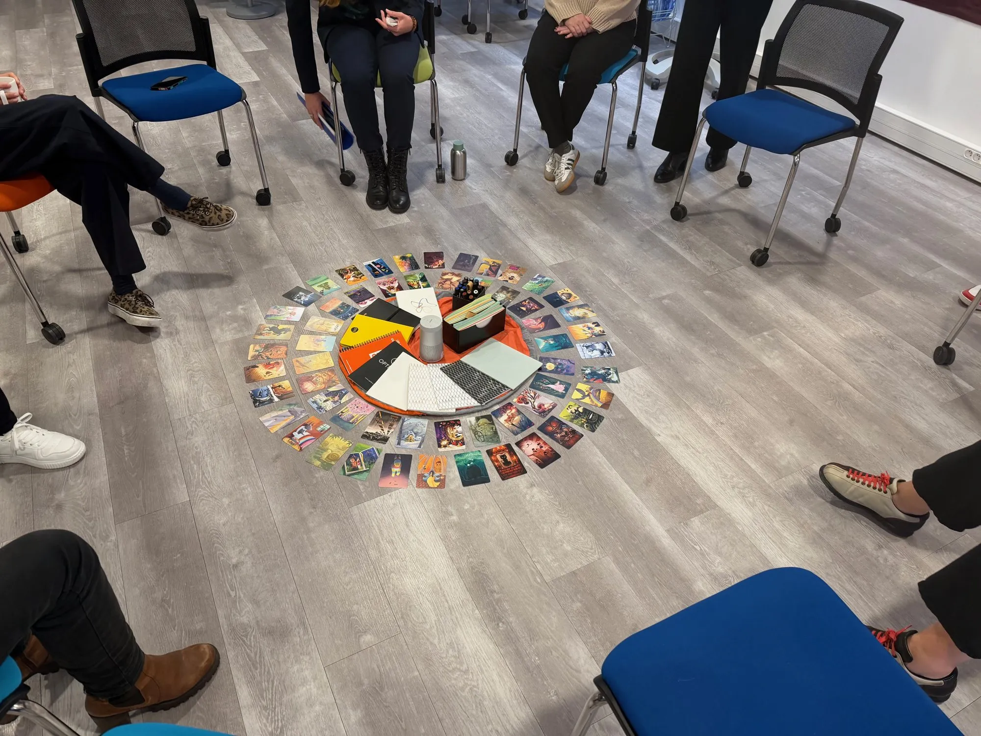 Un cercle de chaises vu d’en haut, avec des cartes images disposées en rond sur le sol