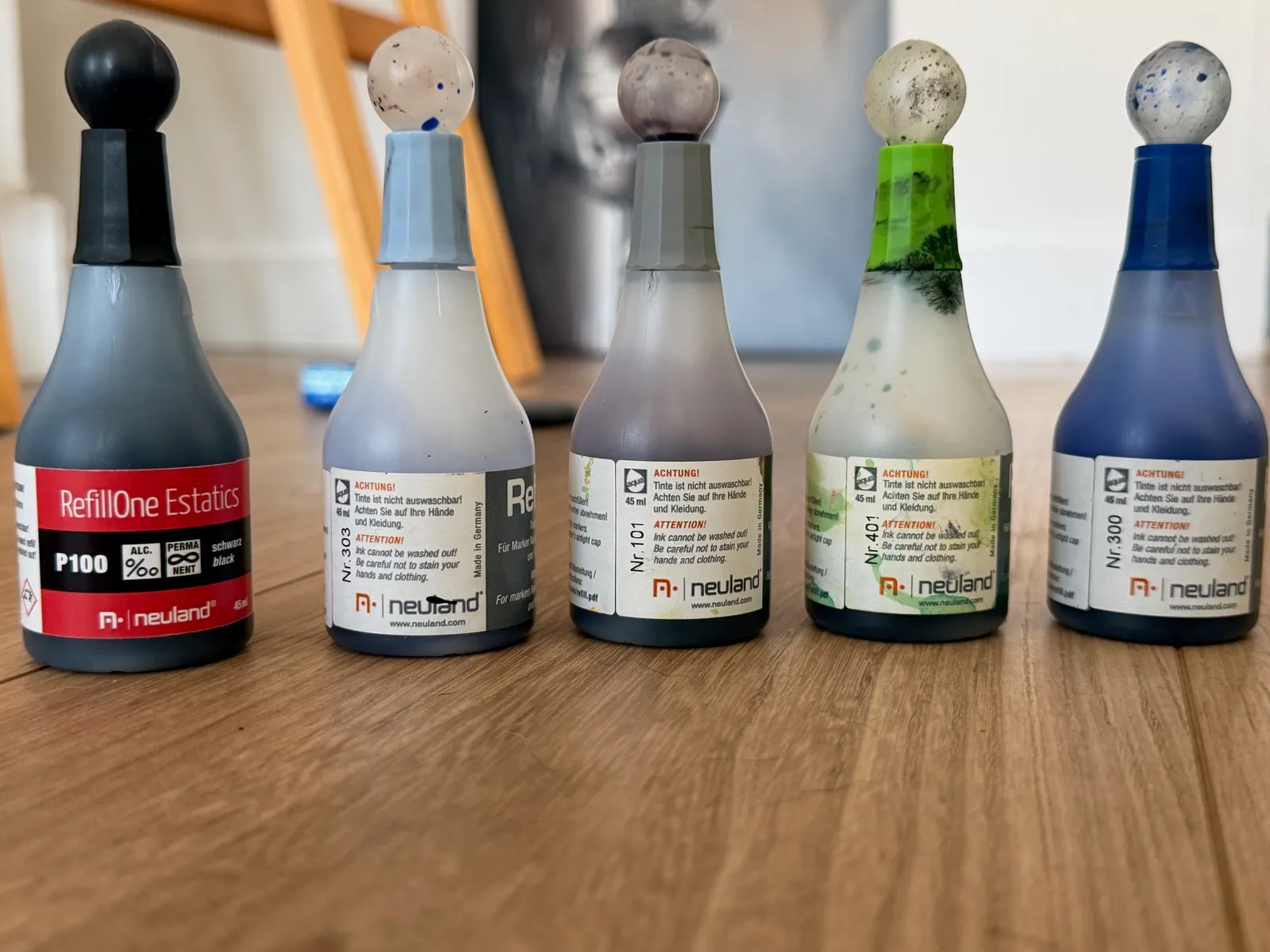 Cinq flacons de recharge alignés, étiquettes tournées vers l’objectif