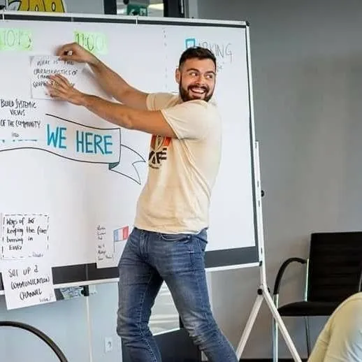 Nicolas Verdot trace au marqueur sur un paperboard, tourné vers le groupe