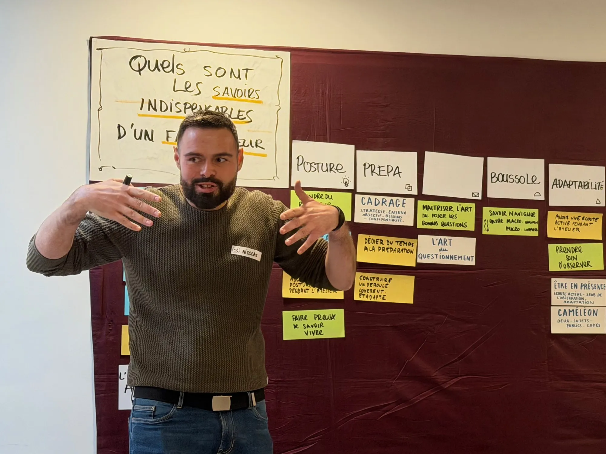 Nicolas Verdot en pleine explication, les mains ouvertes, devant le mur d’affichage